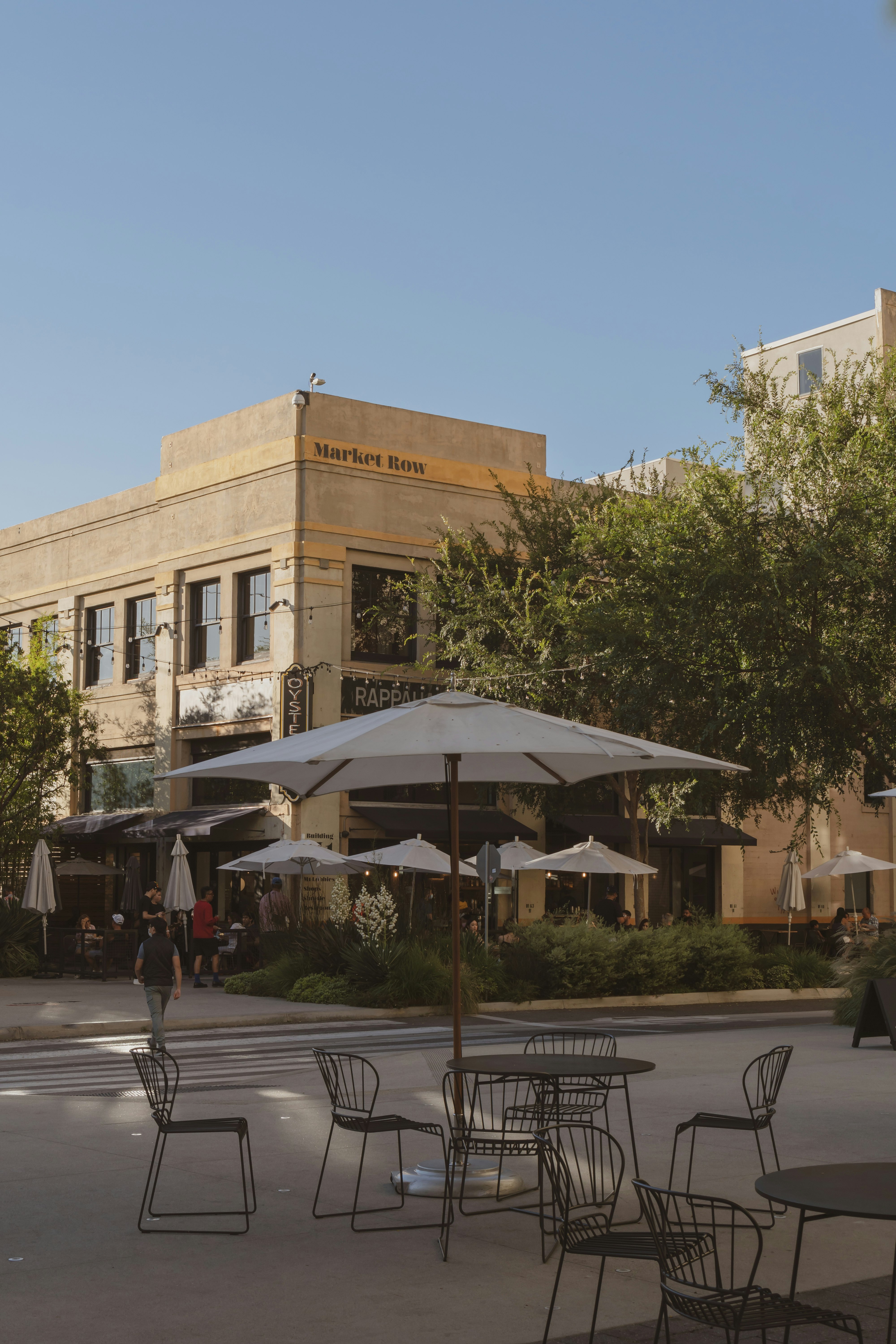 people walking on sidewalk near brown concrete building during daytime